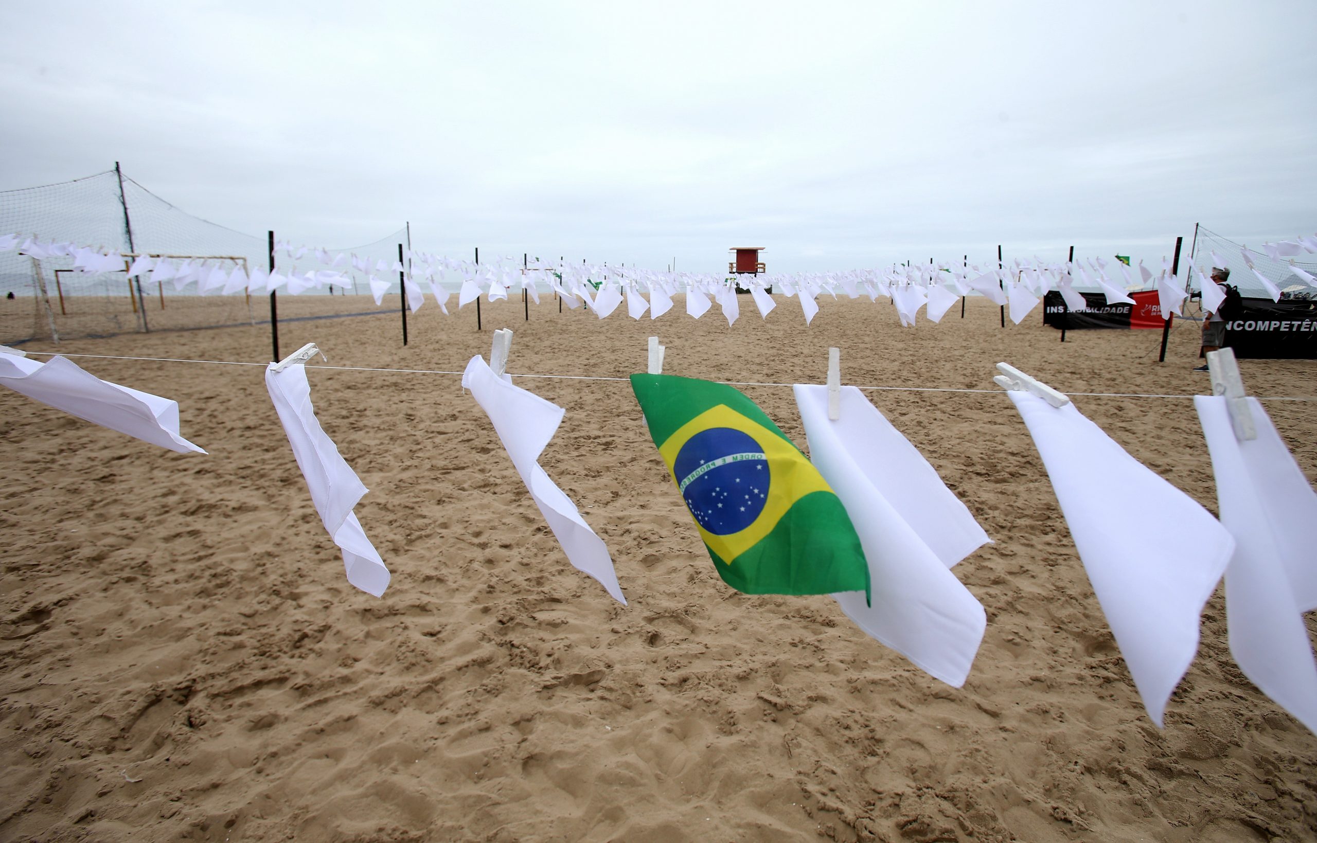 Ato em memória dos quase 600 mil mortos pela Covid no Brasil estende lenços brancos em Copacabana