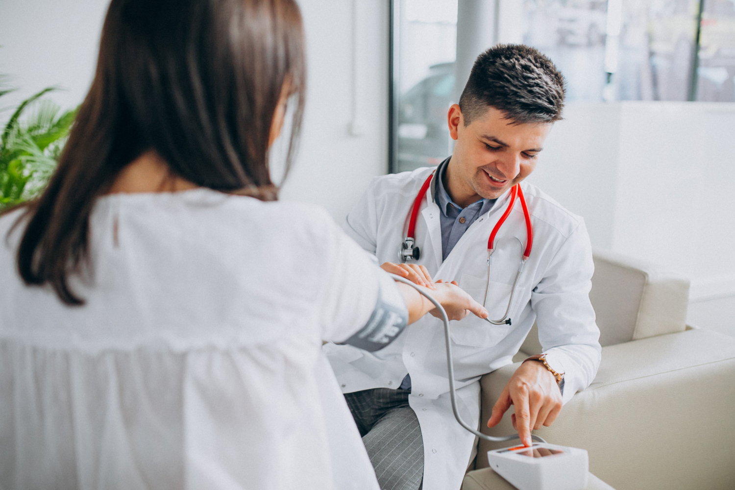 young-male-psysician-with-patient-measuring-blood-pressure