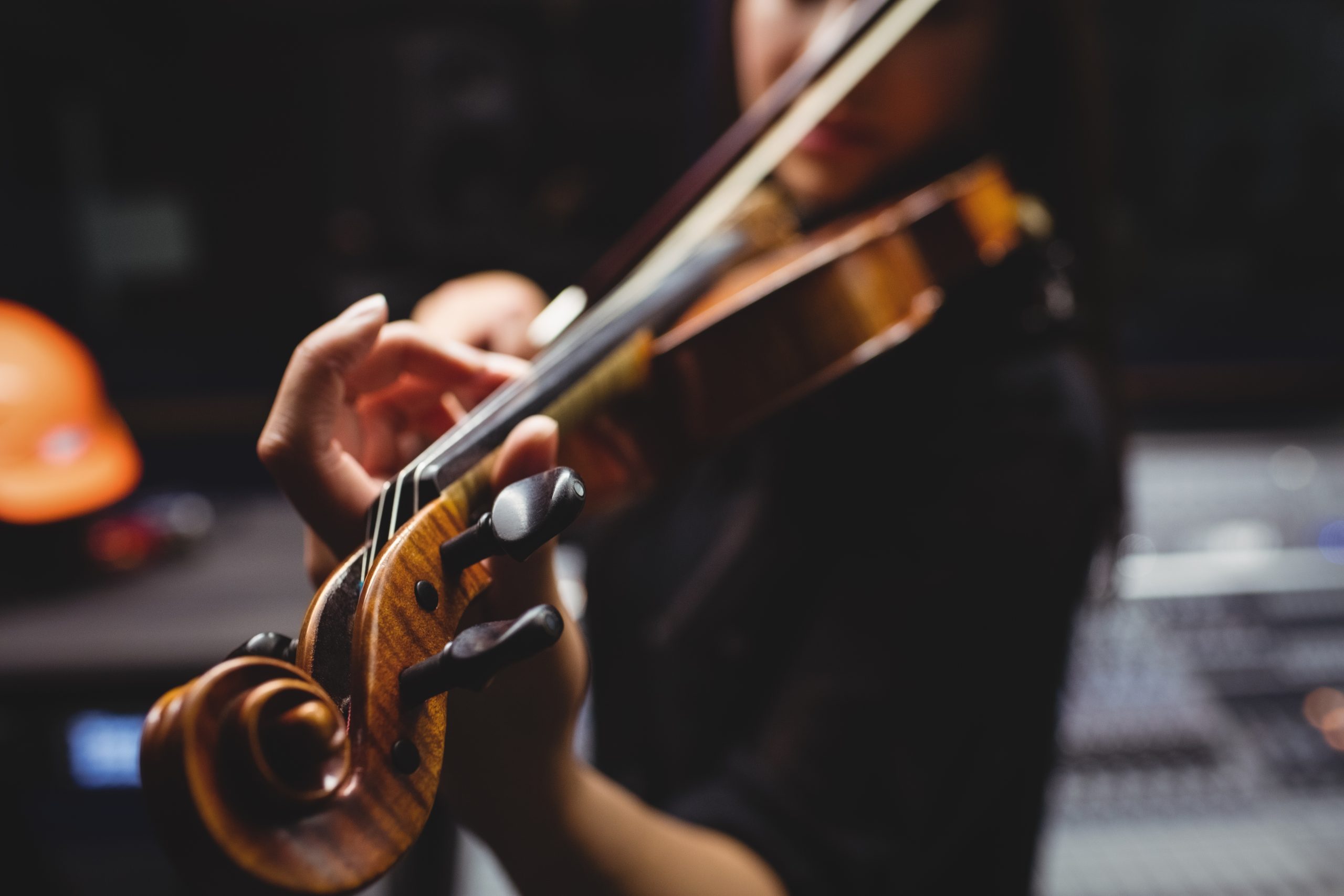 Female student playing violin in a studio